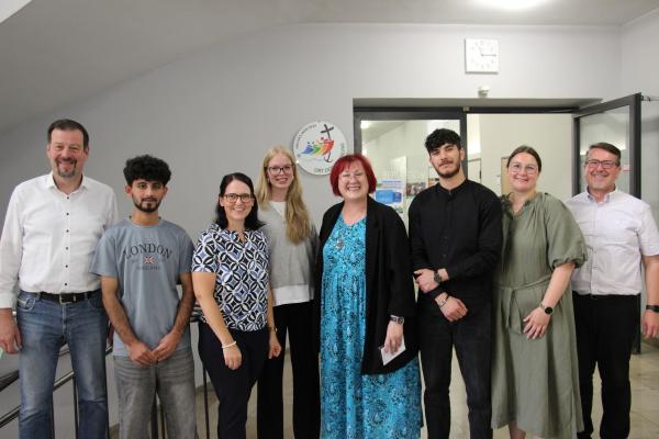 Berufschule II. Schüler, Lehrer, Schulleitung und Pfarrer Markus Wolf (rechts) freuen sich über die Anerkennung